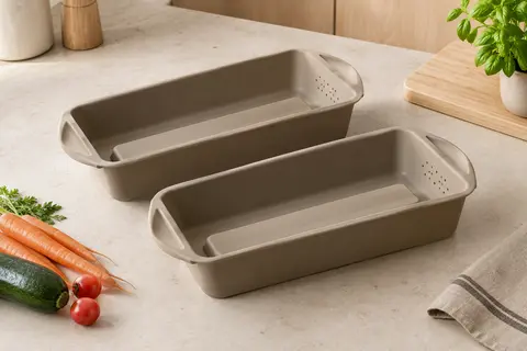 Deux moules en silicone à base surélevée posés sur un plan de travail clair, avec des légumes à proximité