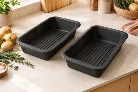Deux moules noirs en silicone à fond rainuré posés sur un plan de travail clair